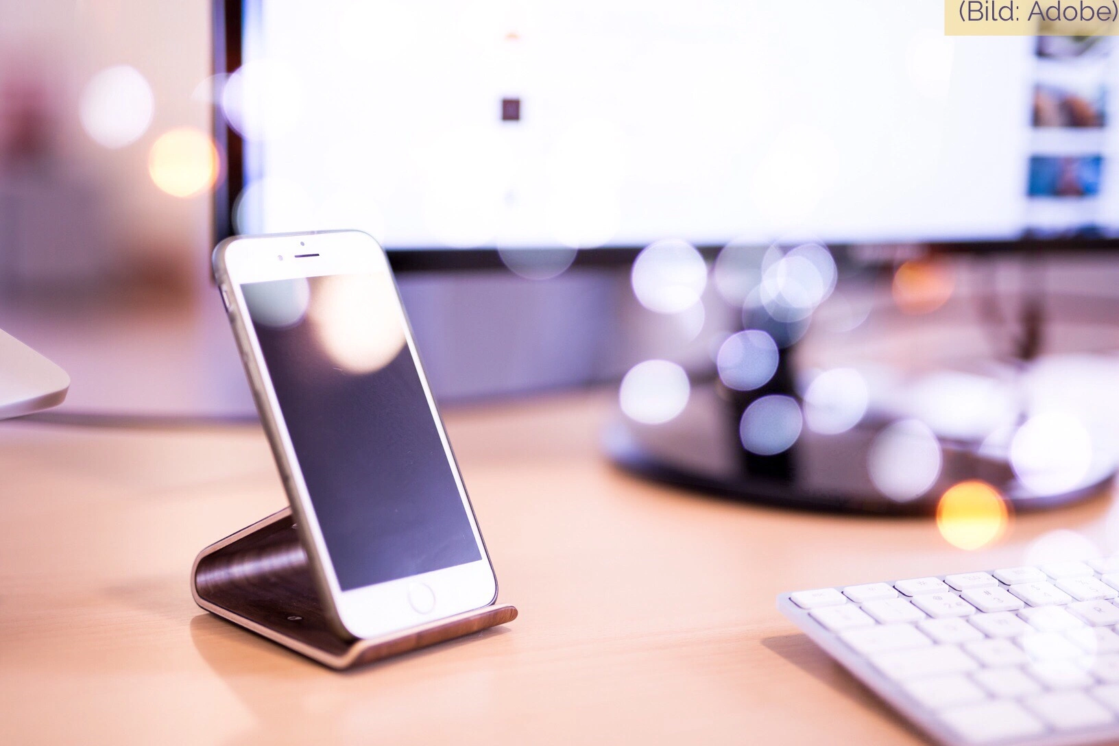 iPhone auf einem Ständer auf dem Schreibtisch – symbolisch für den Apple Akkutausch und die Batterie-Rückerstattung