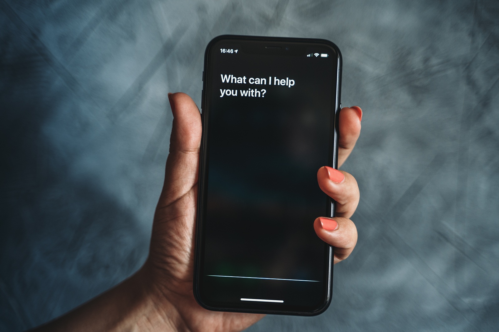 Moscow, Russia - Circa August 2019 : Siri - Apple voice assistant activated by voice in female hand and text on Iphone screen: What can I help you with? Voice mode of interaction with smartphone