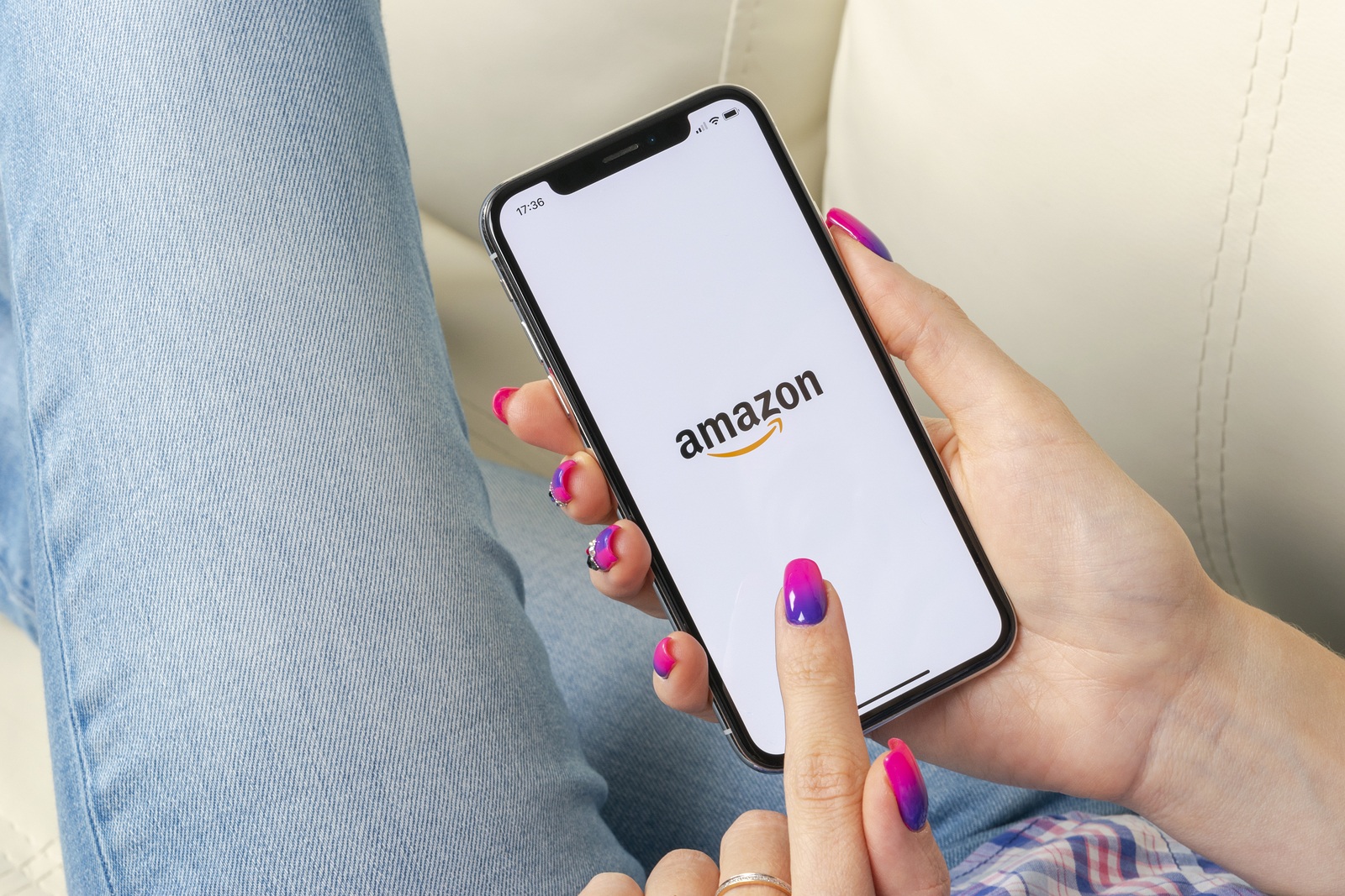 Sankt-Petersburg, Russia, May 30, 2018: Amazon shopping application icon on Apple iPhone X screen in woman hands. Amazon shopping app icon. Amazon mobile application. Social media network
