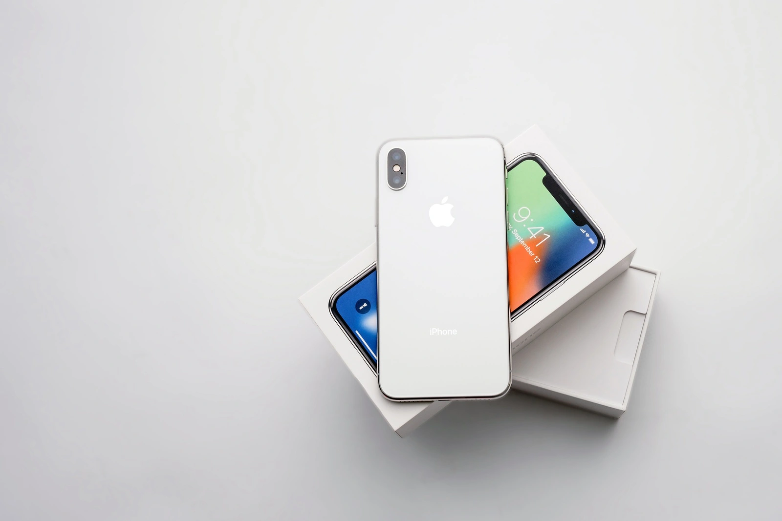 KYIV, UKRAINE - 26 JANUARY, 2018: New Iphone X smartphone model close up. Newest Apple Iphone 10 mobile phone device on white branded Apple box on white table in store