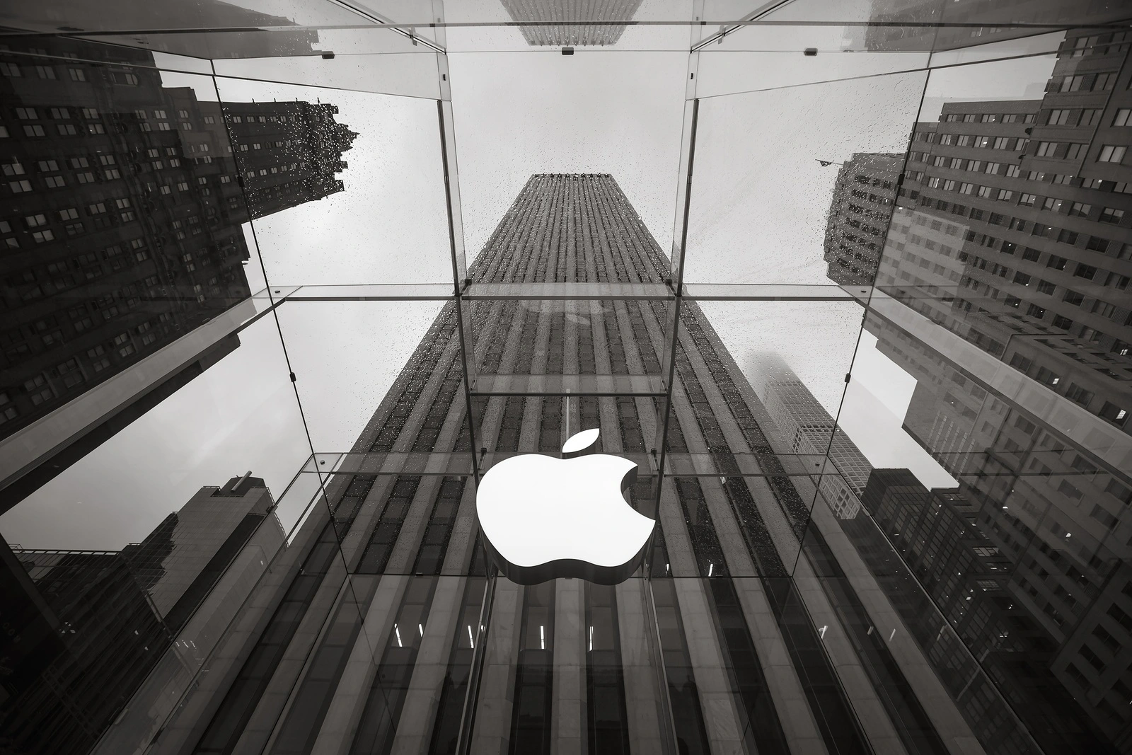 NEW YORK USA - May 04 2016: Apple Store logo at the entrance to the Apple Store on Fifth Avenue New York. Apple Store cube on 5th Avenue on a cloudy rainy day