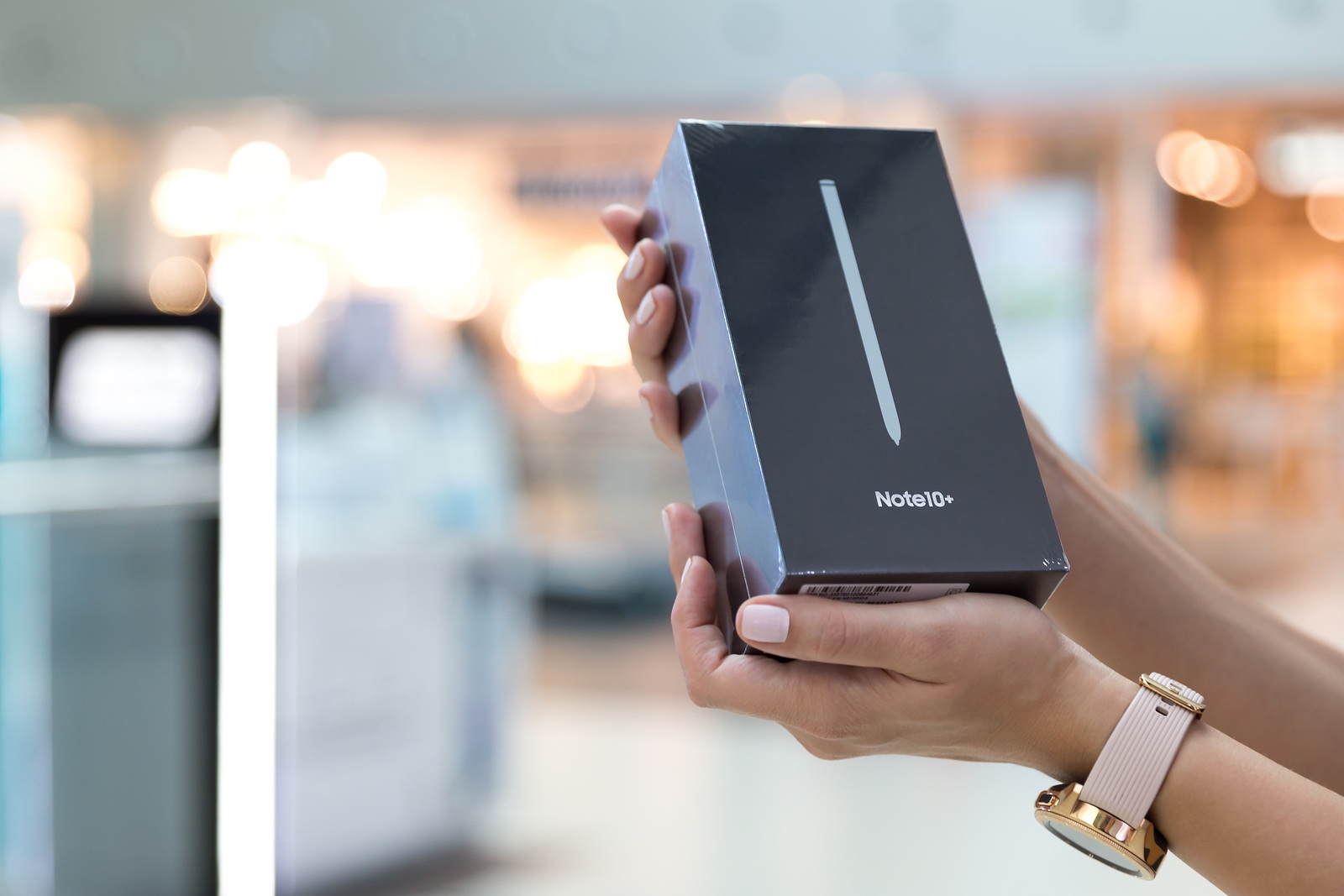 Belgrade, Serbia - August 23, 2019: New Smartphone, Samsung Galaxy Note 10+ is displayed in original cardboard box, holded in hands against isolated blurry background