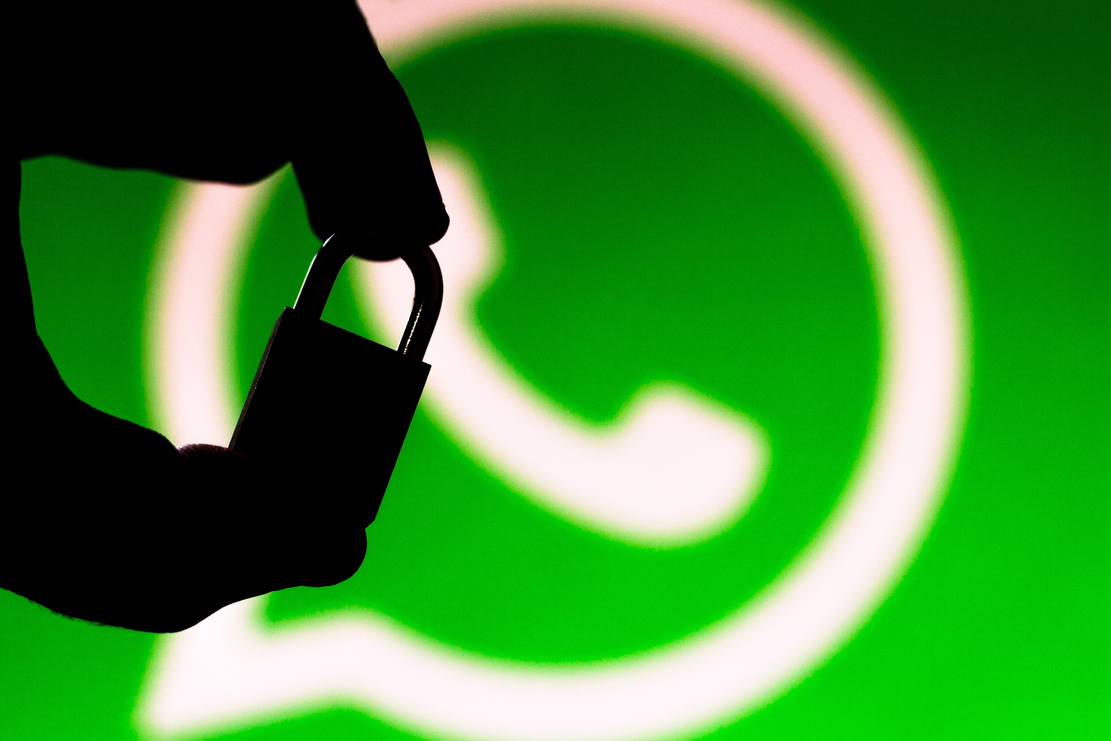 June 30, 2019, Brazil. In this photo illustration WhatsApp security concept. Silhouette of a hand holding a padlock in front of the WhatsApp logo.