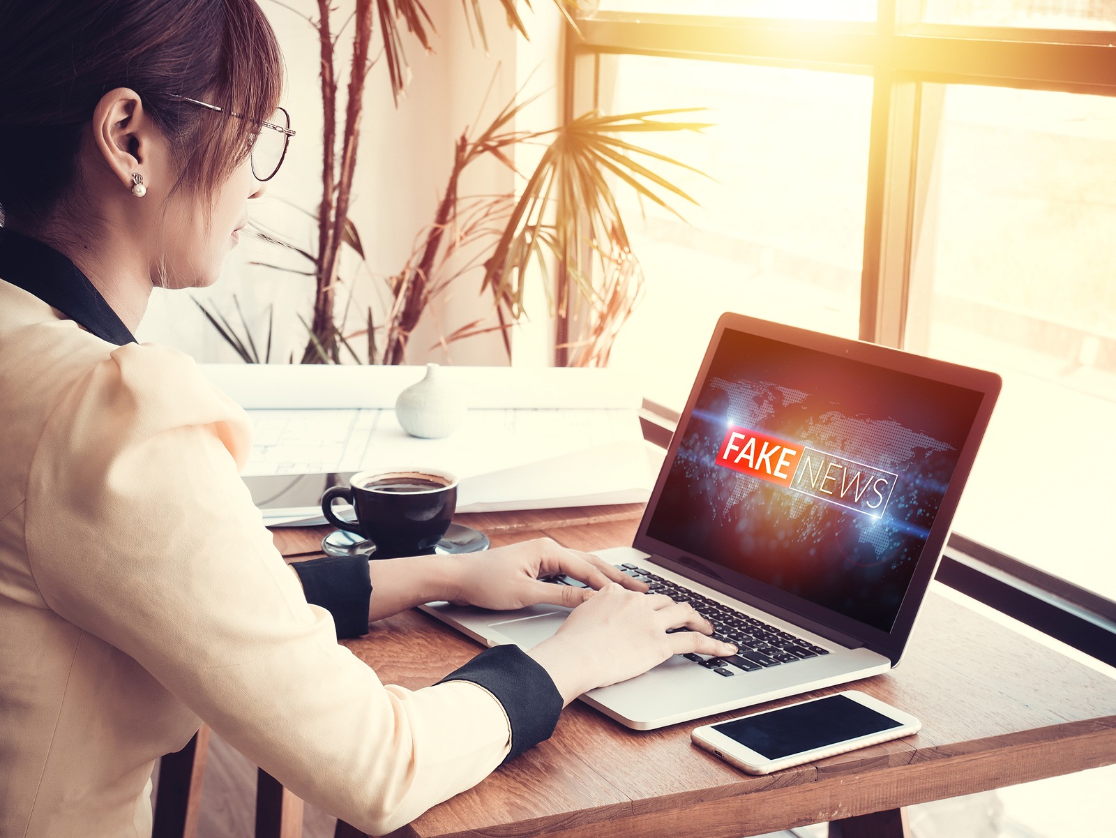 business woman reading fake news or HOAX on internet content via laptop at workplace