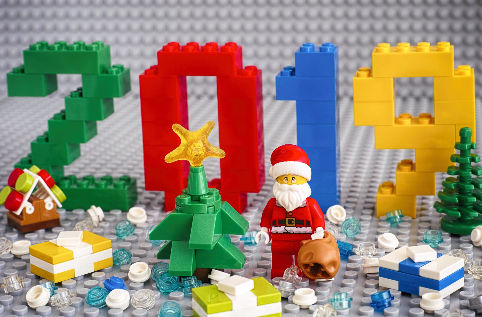 Tambov, Russian Federation - September 02, 2018 Numbers 2019 made by Lego blocks, christmas tree, Santa Clause with bag, presents and Lego round blocks on Lego gray baseplates. New Year concept. Studio shot.