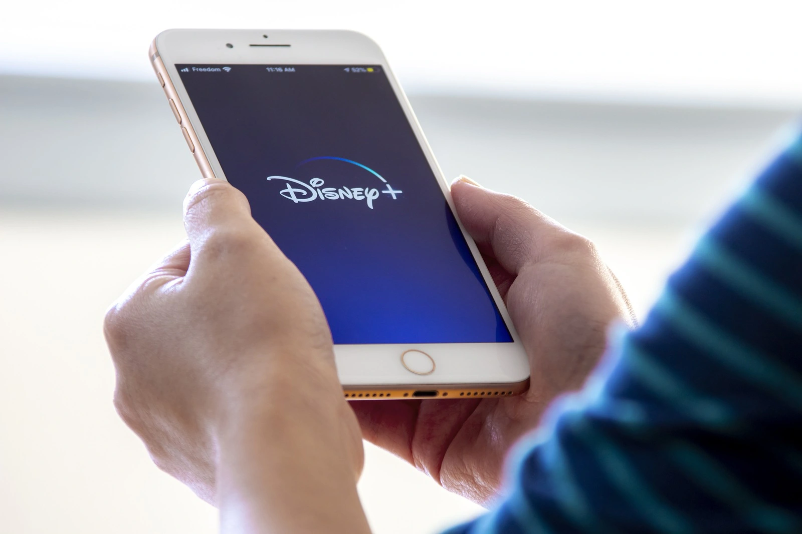 Calgary, Alberta. Canada Nov 28 2019: Woman holds an iPhone plus with the new Disney+ app on her hands. Disney+ release a new update of its online video streaming service.Illustrative
