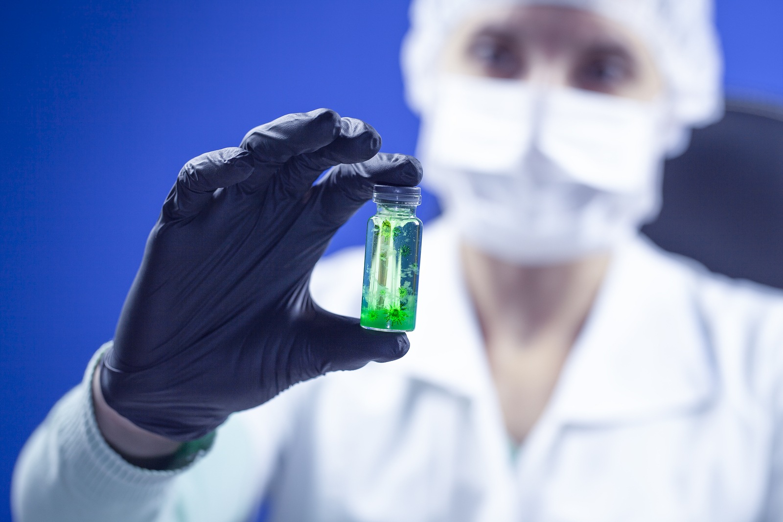 Concept of coronavirus quarantine. MERS-Cov (middle East respiratory syndrome coronavirus), Novel coronavirus (2019-nCoV), test tube with coronovirus in the hands of a virologist in a chemical laboratory, blue tinted