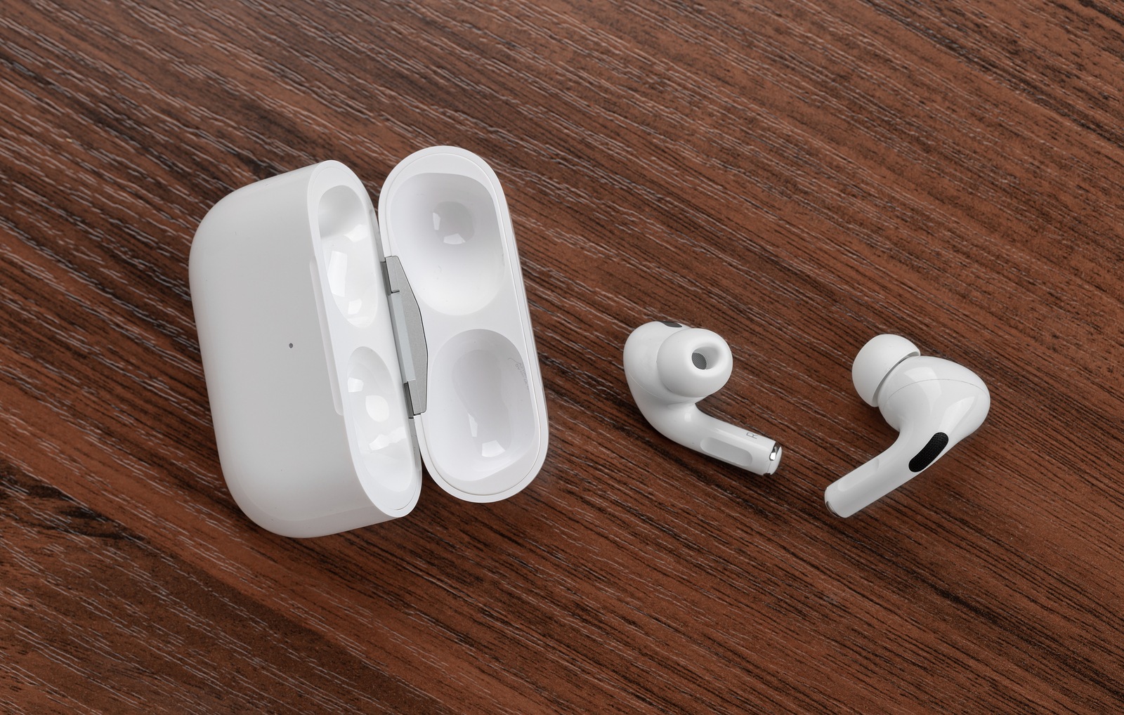 Rostov-on-Don, Russia - December 2019. Apple AirPods Pro on a wooden table. Wireless headphones and charging case close-up.