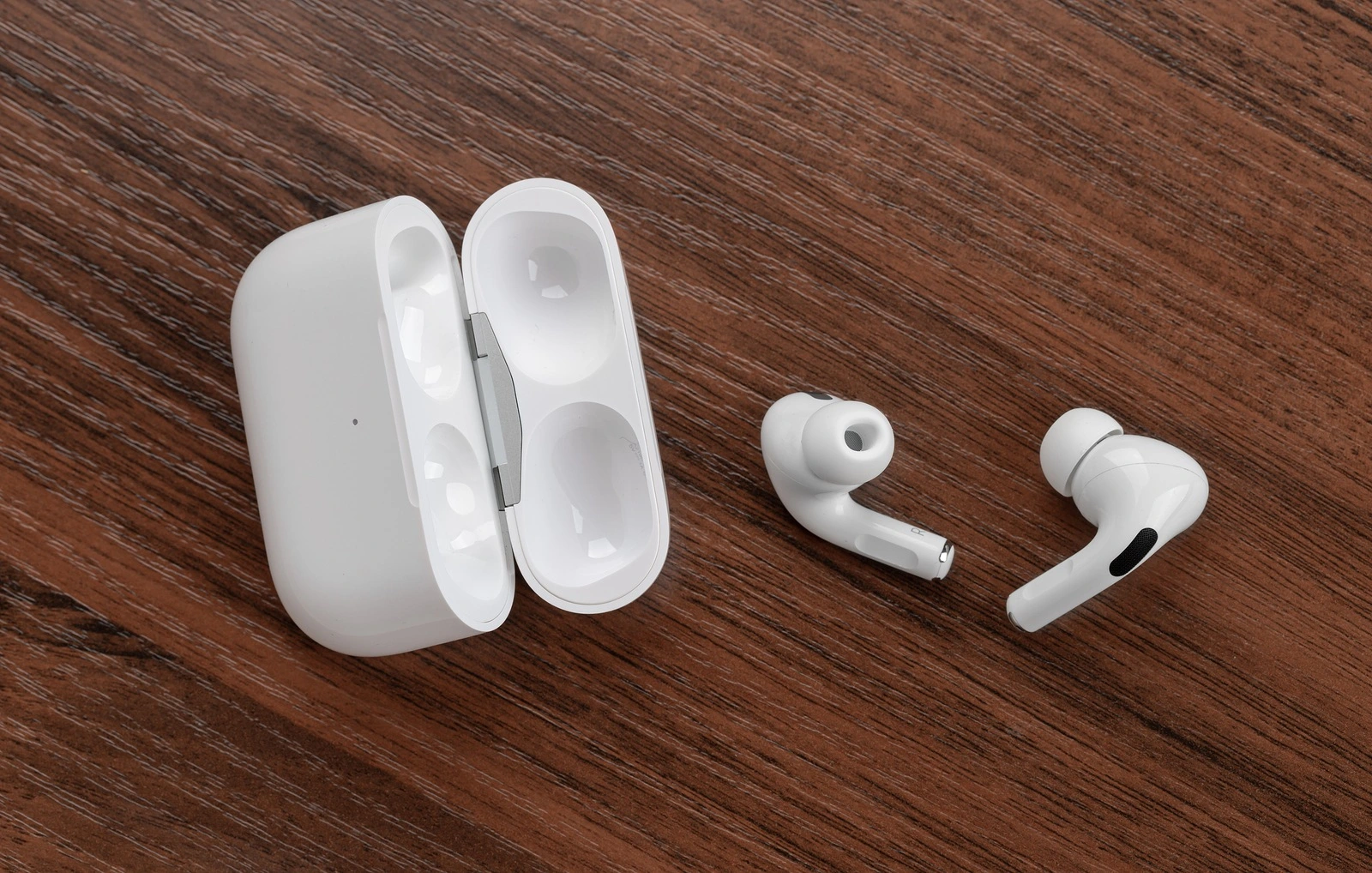 Rostov-on-Don, Russia - December 2019. Apple AirPods Pro on a wooden table. Wireless headphones and charging case close-up.