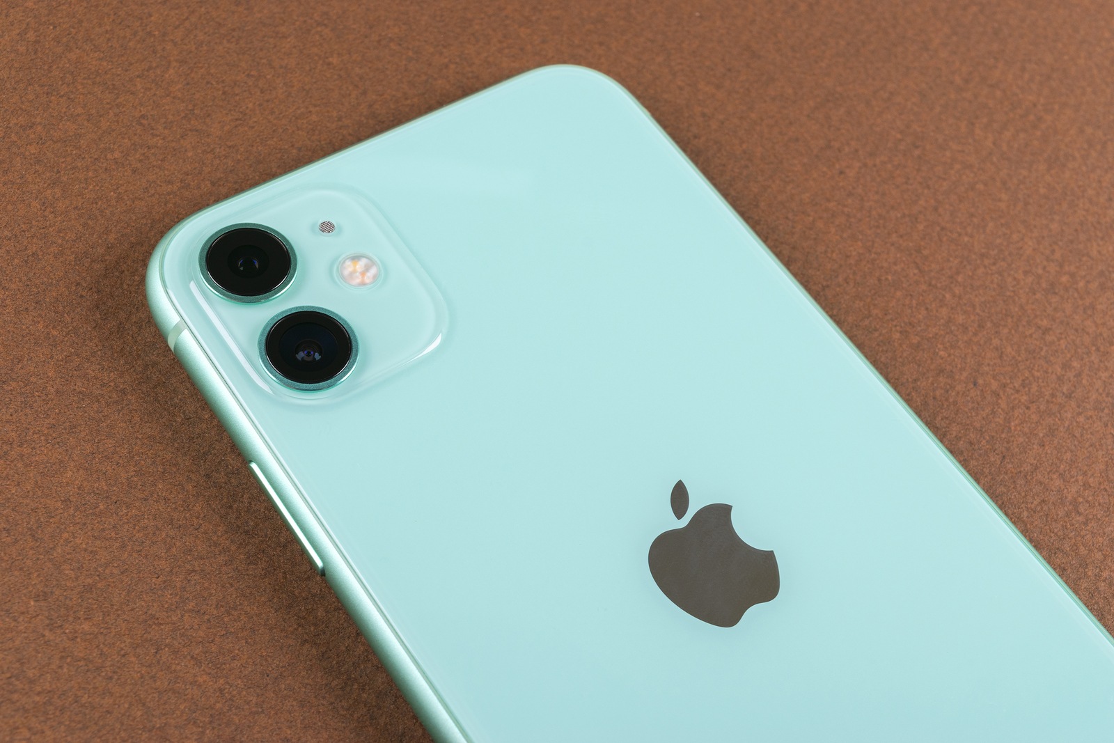 Helsinki, Finland, January 13, 2020: Apple iPhone 11 camera and headphones close up on office desk. Studio shot of the original green Apple iPhone 11 camera