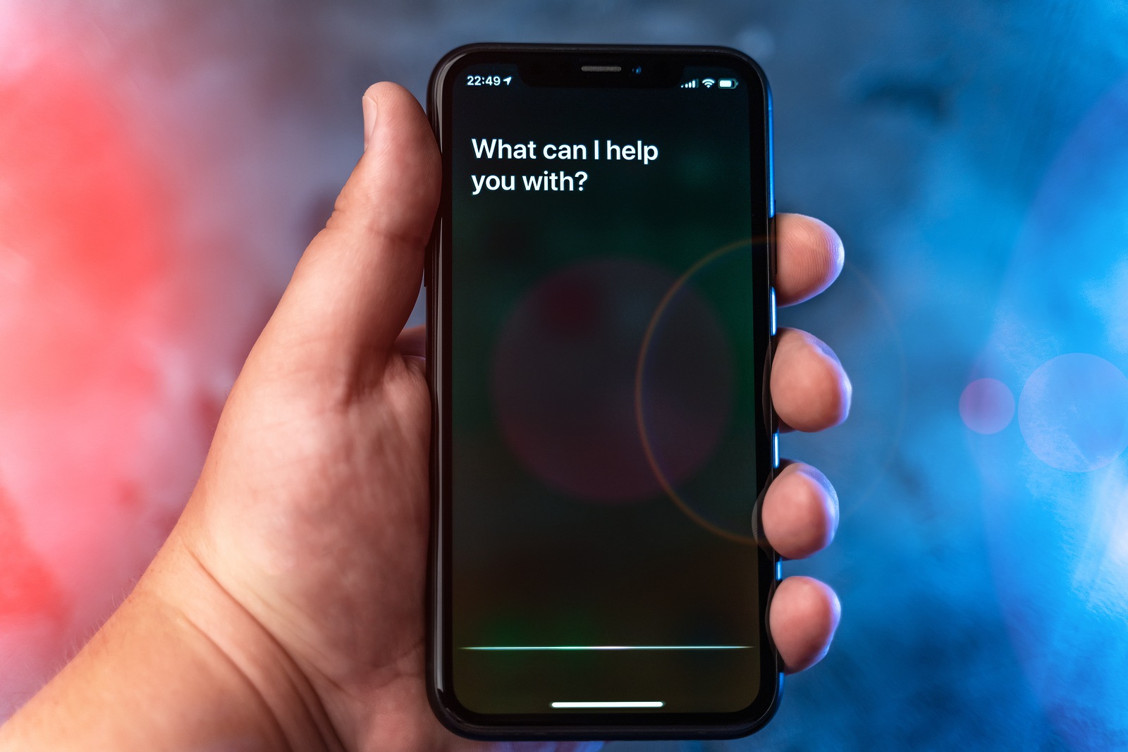 Moscow, Russia - Circa August 2019 : Siri - Apple voice digital assistant activated by voice in male hand and text on Iphone screen: What can I help you with? Voice mode of interaction with smartphone