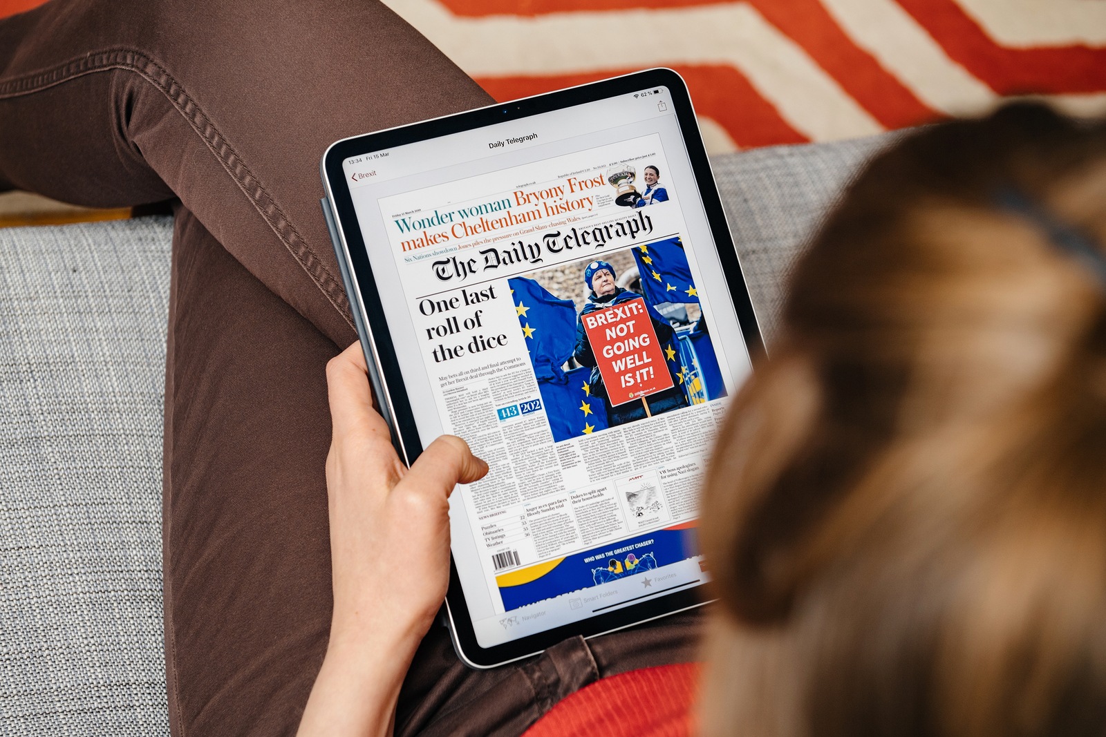 Paris, France - Jun 2, 2019: Overhead view of a woman reading on on Apple news app on Ipad tablet the electronic version of British The Daily Telegraph news about Brexit