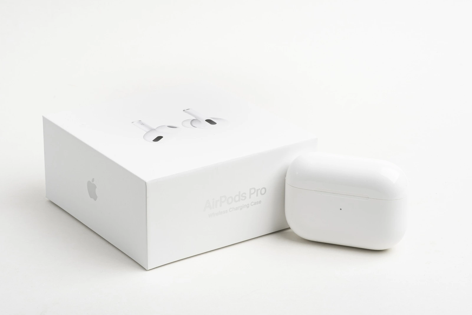 Vidalia, Georgia / USA - December 14, 2019 - A studio product shot of the white packaging box with the closed white charging case if Apple AirPods Pro set on a plain light color background.