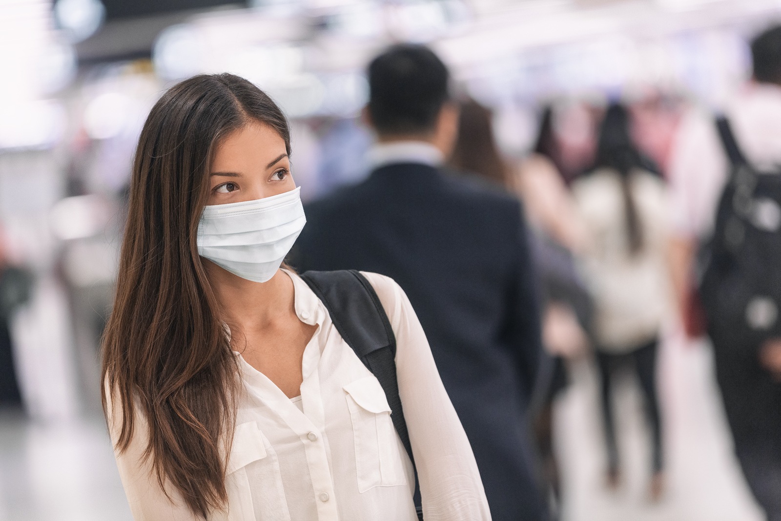 Virus mask Asian woman travel wearing face protection in prevention for coronavirus in China. Lady walking in public space bus station or airport.