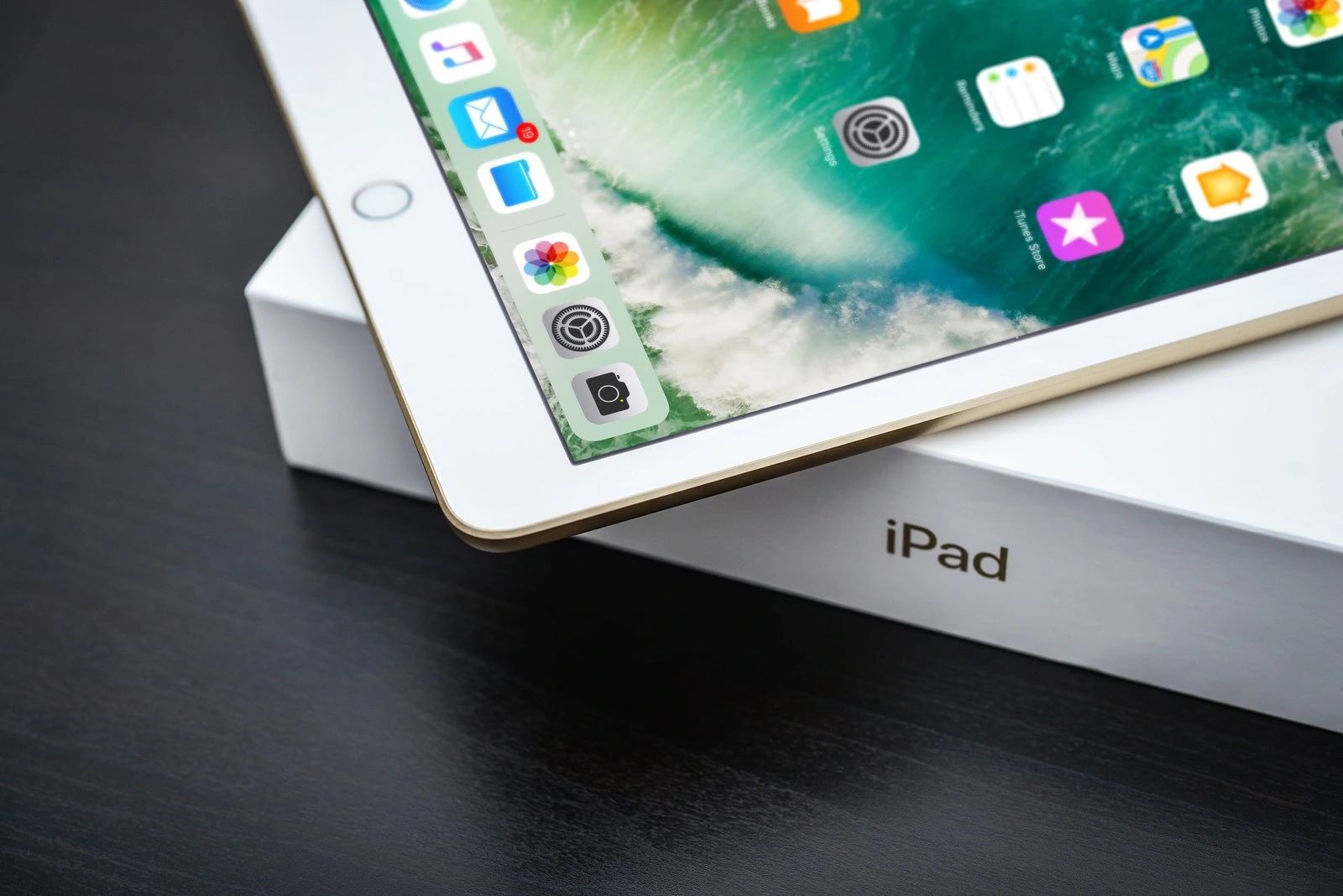 Kyiv, Ukraine - Fabruary 6, 2018: Brand new white Apple iPad Gold with box on black wooden background closeup, 7th generation of the iPad, developed by Apple inc. and was announced on March 21, 2017