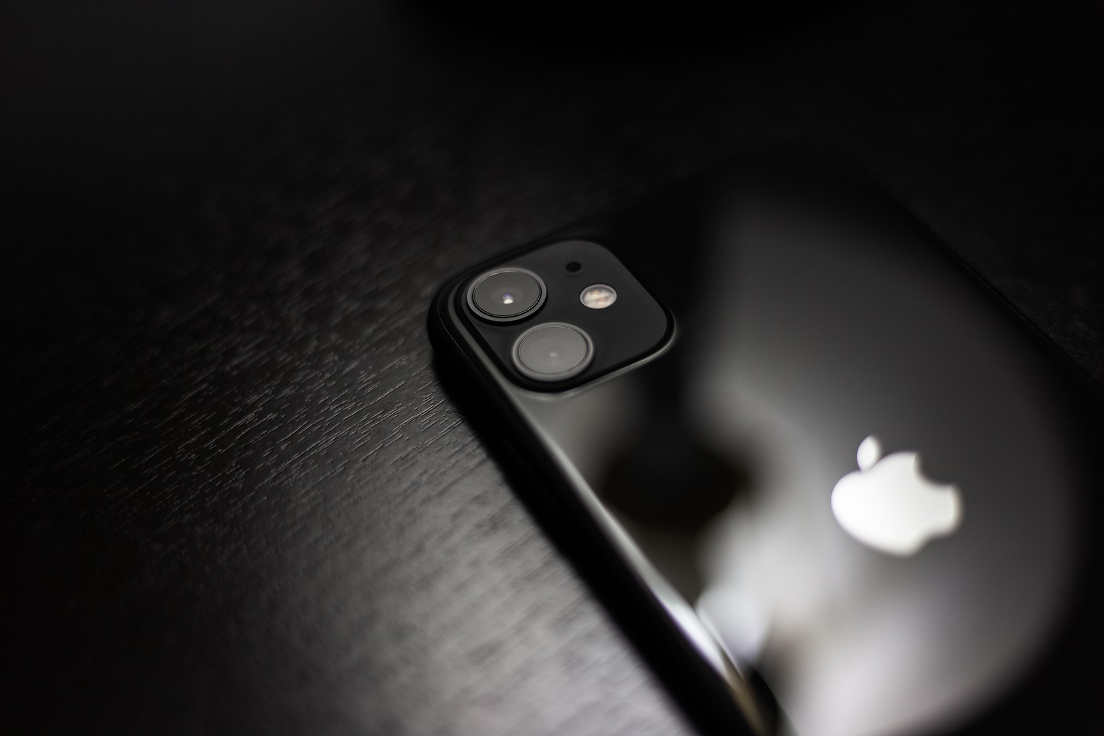 Moldova, Chisinau - 03.11.2019: Close-up of black iPhone 11 on dark wooden table.