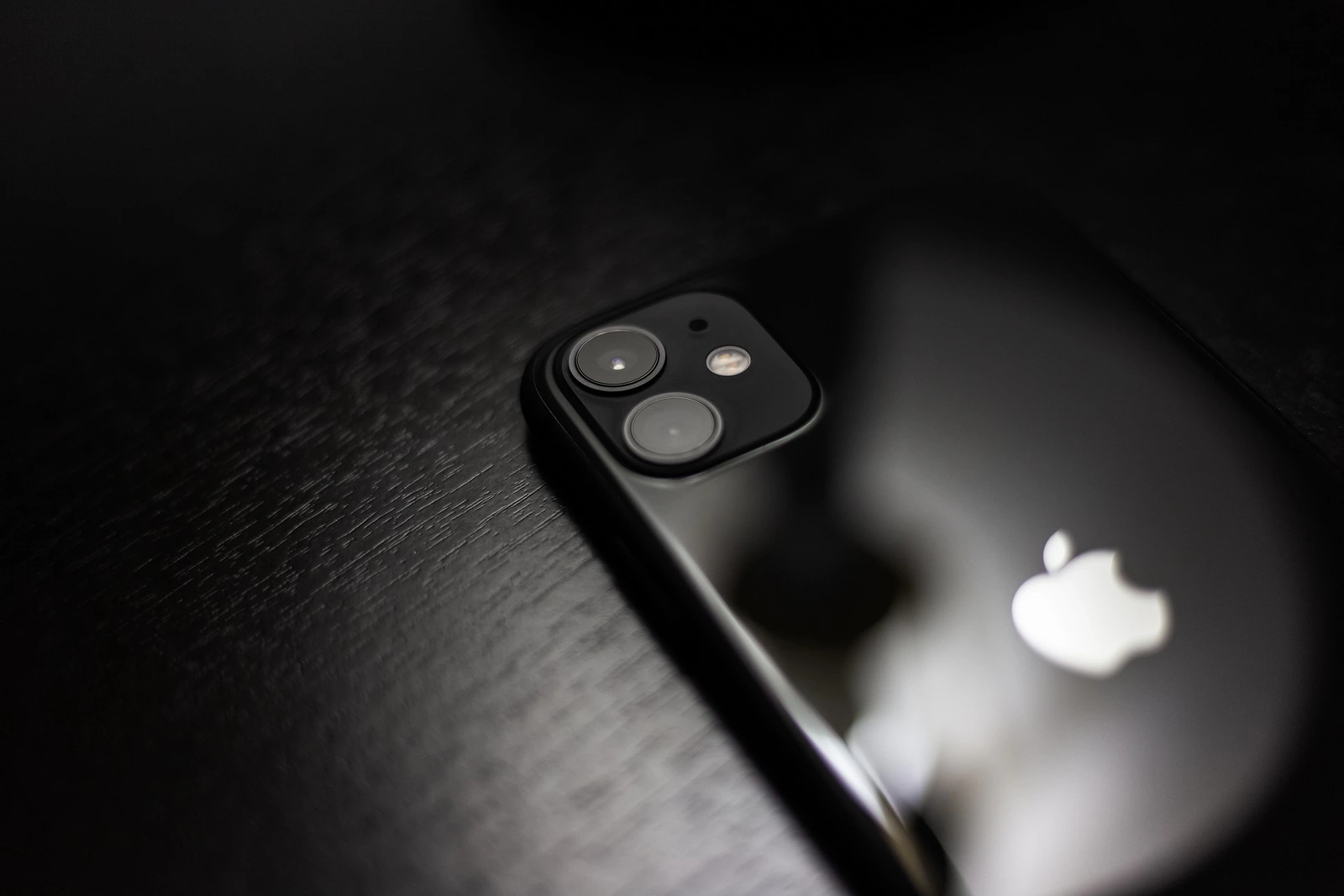 Moldova, Chisinau - 03.11.2019: Close-up of black iPhone 11 on dark wooden table.