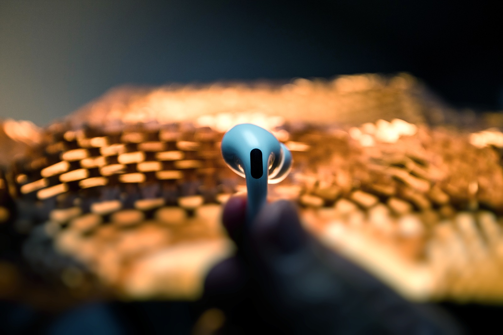 Paris, France - Oct 30, 2019: Man hand holding against abstract background futurstic new Apple Computers AirPods Pro headphones with Active Noise Cancellation for immersive sound