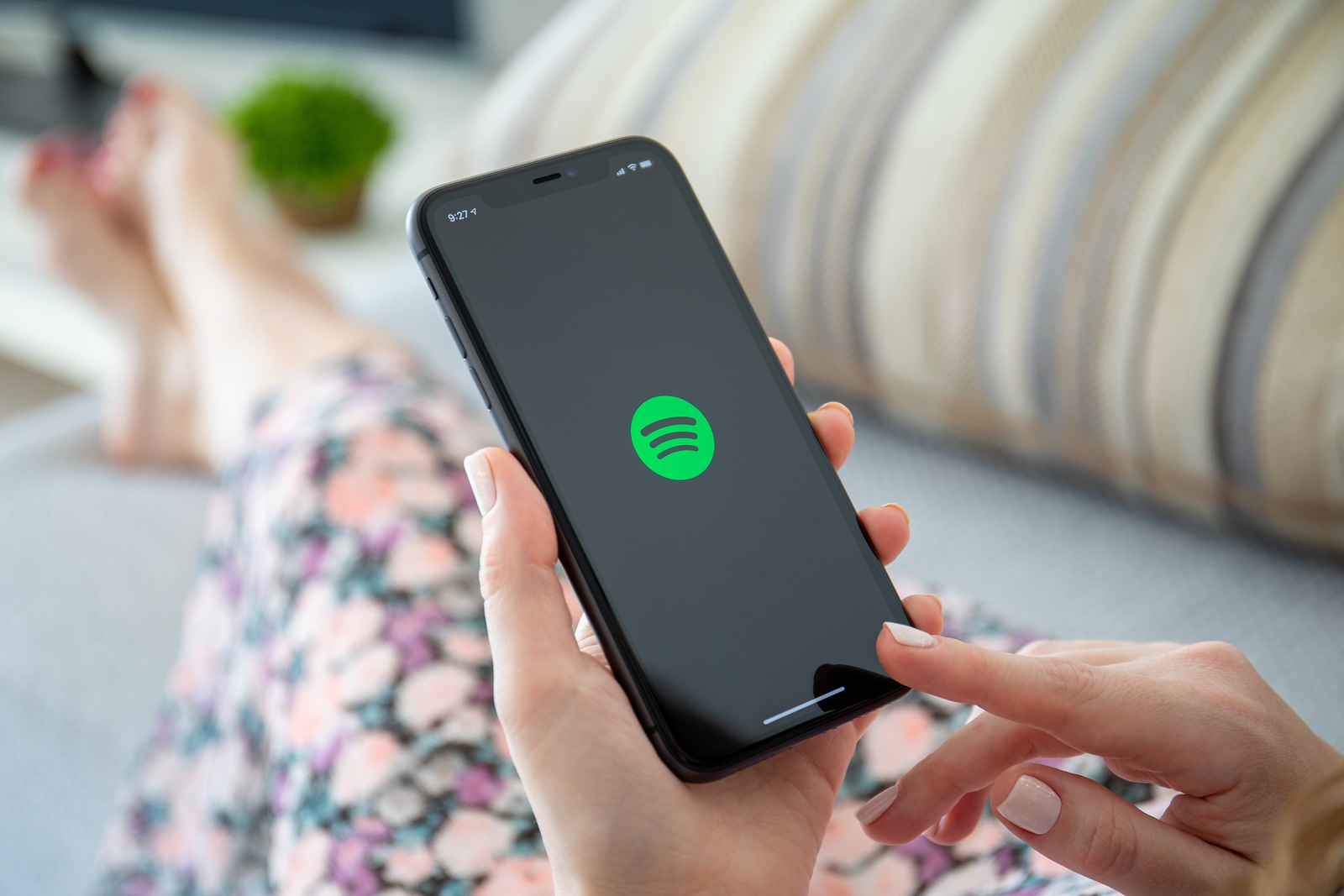 Anapa, Russia - October 4, 2019: Woman holding iPhone 11 with music service Spotify on the screen. iPhone 11 was created and developed by the Apple inc.