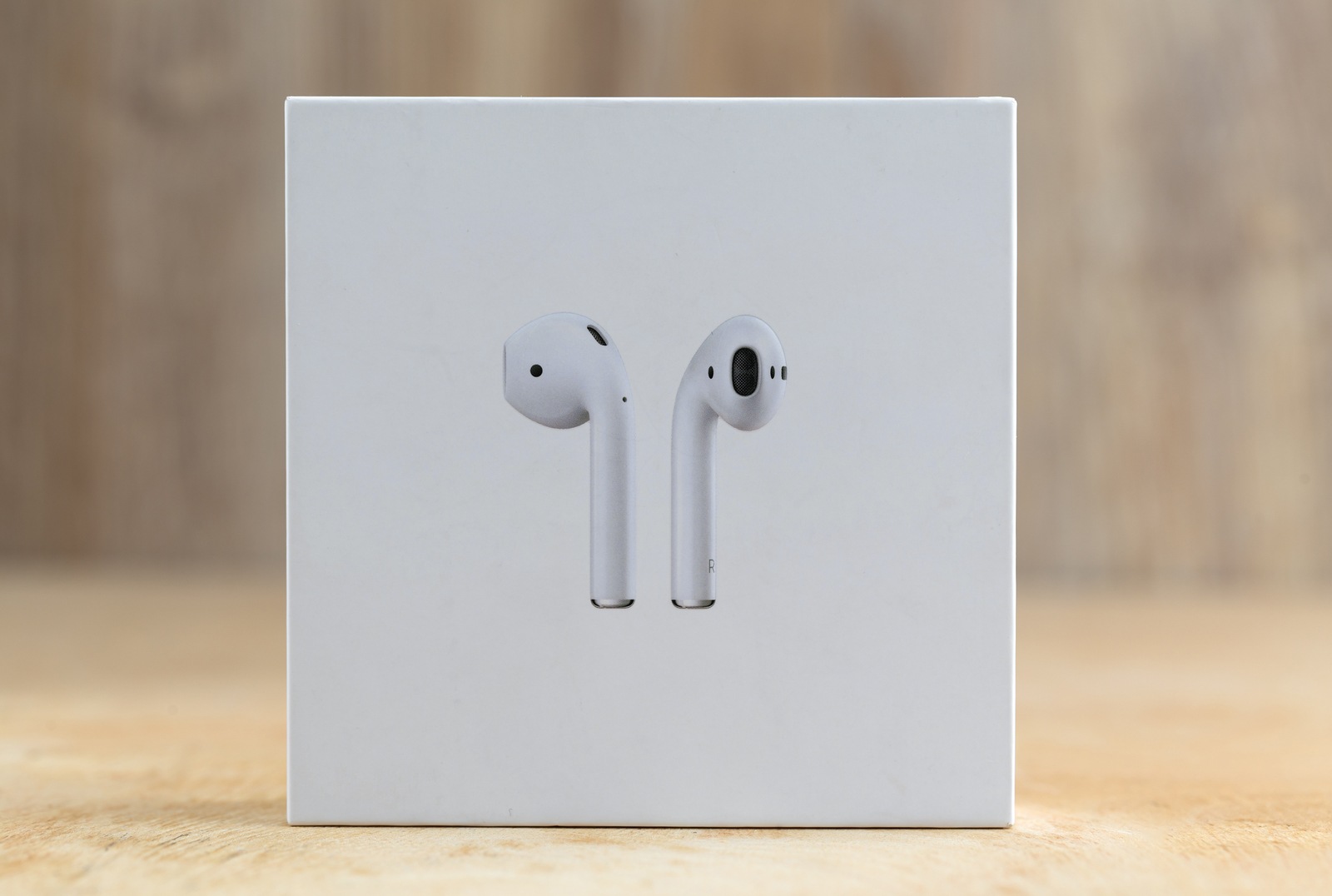 Rostov-on-Don, Russia - December 2018.  Apple Airpods in a box on a wooden surface. New Airpods sealed in a box close-up on a wooden table.
