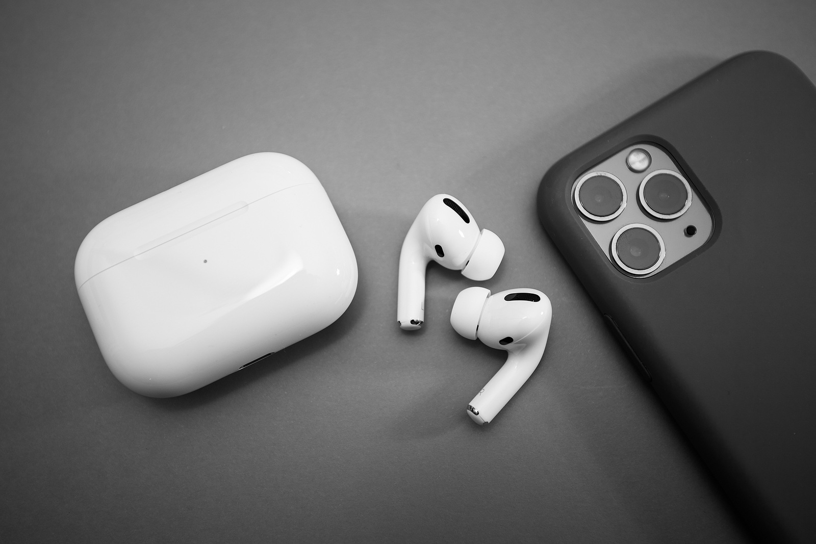 Paris, France - Oct 30, 2019: Charging case and the new iPhone 11 Pro next to New Apple Computers AirPods Pro headphones with Active Noise Cancellation for immersive sound