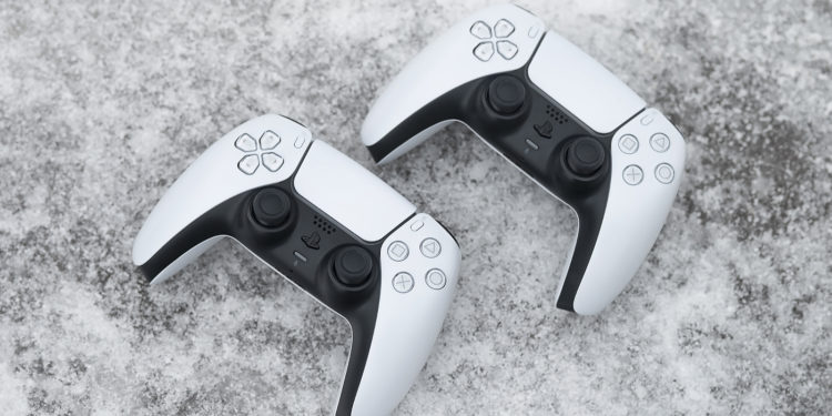 Moscow, Russia - March 8 2021: Sony PlayStation 5 home video game console and game controller. New product from Sony, wireless white PlayStation 5 on an old shabby dirty wooden bench background