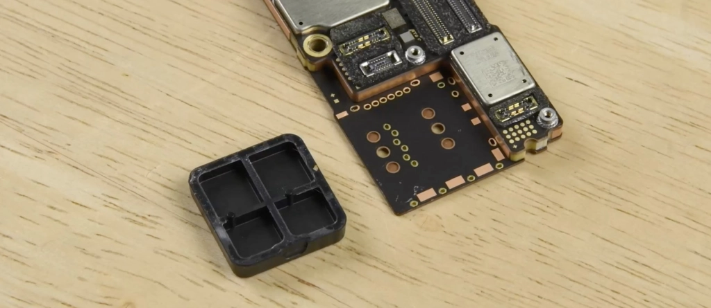 iPhone 14 Pro Max Teardown: Logikplatine mit A16 Bionic Chip und iFixit Plastikabstandshalter statt SIM-Kartenfach