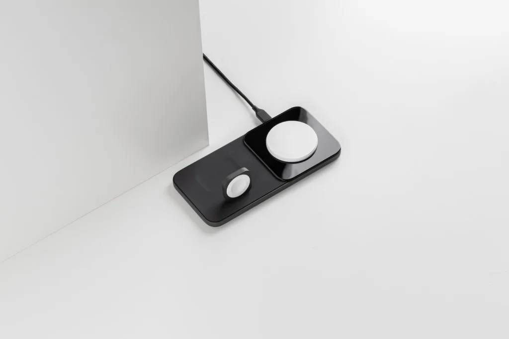 Das Nomad Base One Max 3-in-1 Ladegerät in der Farbe Karbid Schwarz auf einer weißen Oberfläche.