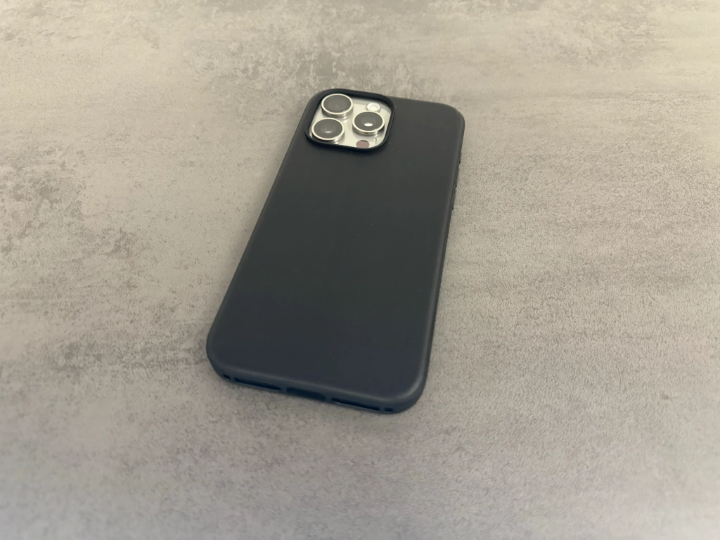 Schwarze Nomad iPhone 15 Lederhülle auf der Rückseite eines iPhones mit Fokus auf das Kameramodul