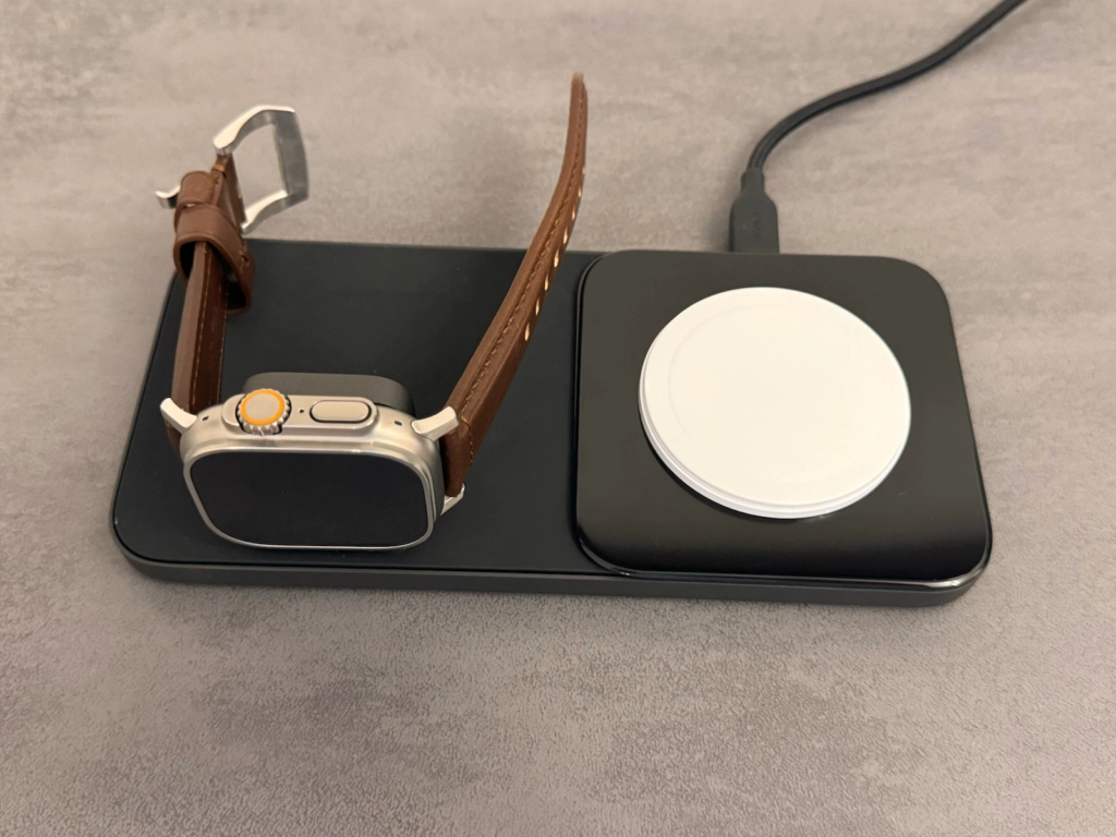 Apple Watch Ultra mit braunem Nomad Lederarmband auf einer kabellosen Nomad Base One Max Ladestation