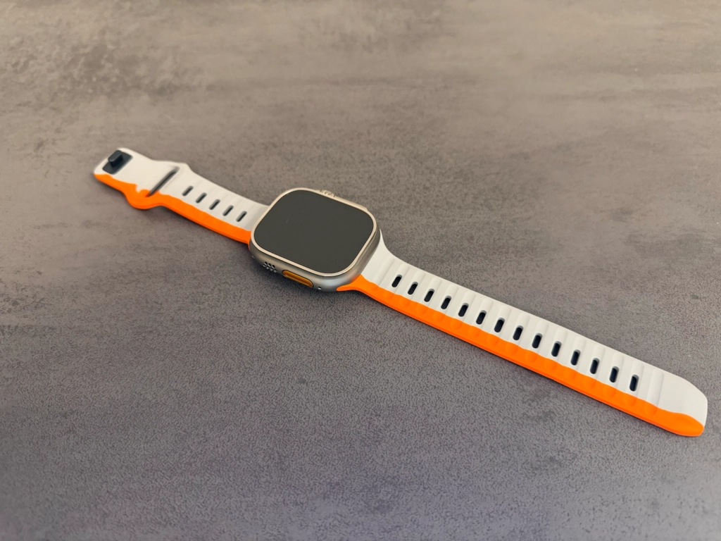 Nomad Sport Armband für die Apple Watch Ultra in Weiß und Orange mit Fokus auf den Aluminium-Verschluss.