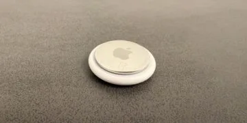 Apple KI-Pin: ein AirTag als Größenvergleich auf grauer Fläche