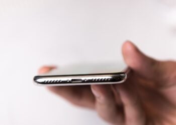 Symbolic image for the iPhone 20: iPhone in hand, view of the underside with speaker grille and connector.