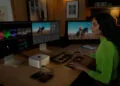 Arbeitsplatz mit Mac Studio und drei externen Displays, eine Person bearbeitet Video an Tastatur und Farbkorrektur-Panel