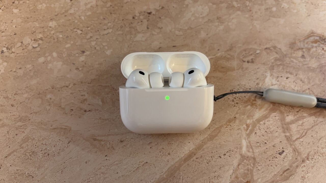 Geöffnetes Ladecase mit zwei Ohrhörern, deren Stiele sichtbar sind – dort sollen die AirPods mit Kamera ihre Sensoren tragen