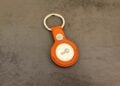 AirTag 2 in a fuchsia FineWoven key ring on a dark surface, the type of tracker used in AirTag stalking