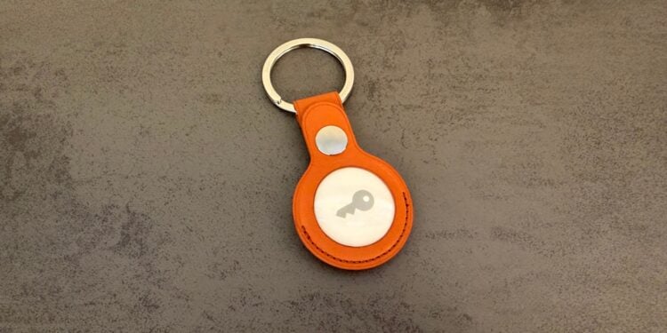AirTag 2 im fuchsroten Feingewebe-Schlüsselanhänger auf dunklem Untergrund, AirTag-Stalking betrifft genau diese Tracker