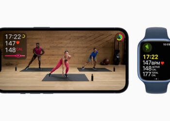 Apple Fitness+ Training auf einem iPhone mit drei Trainern im Studio, daneben eine Apple Watch mit Herzfrequenz und Kalorienwerten