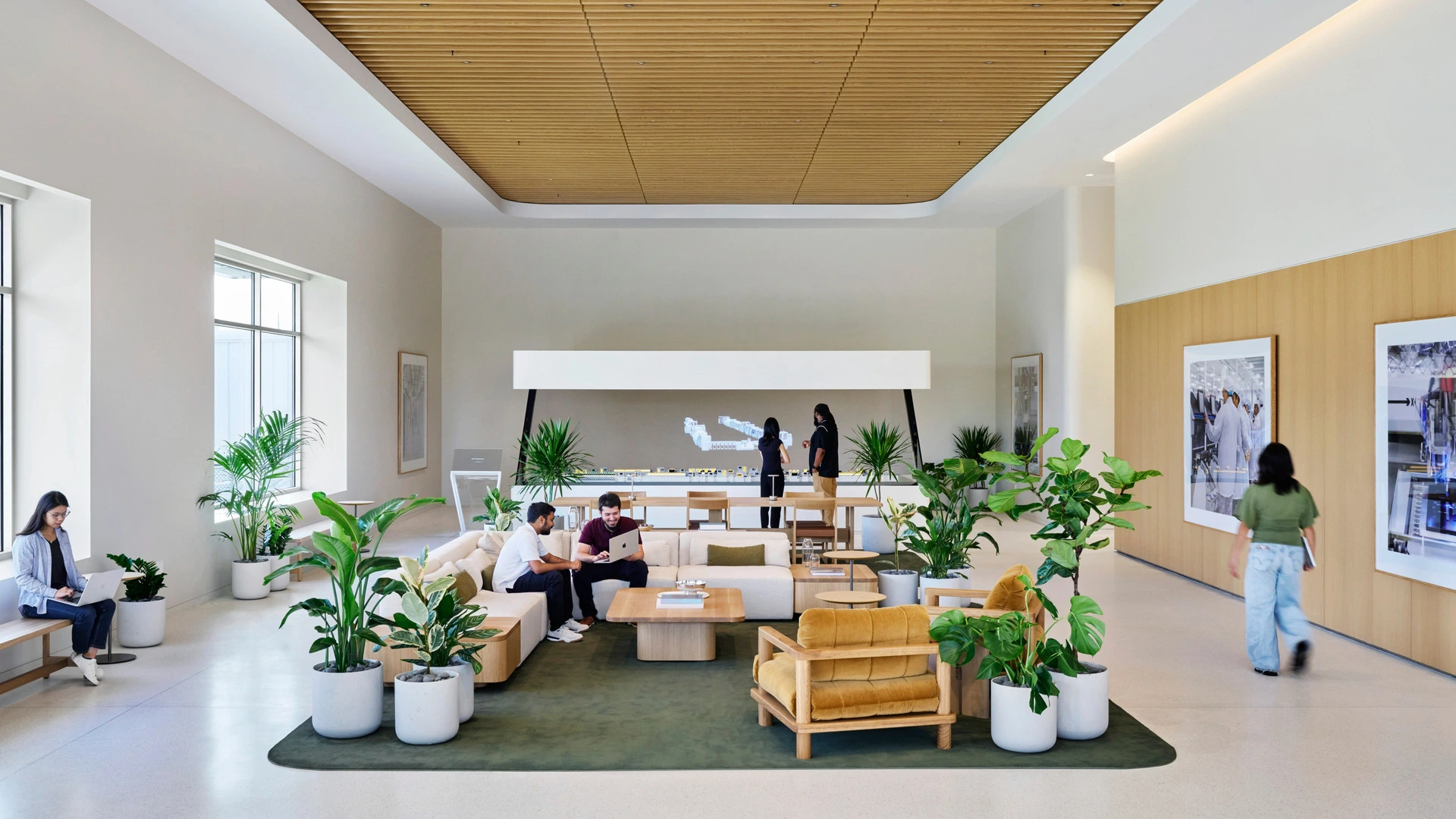 Der Empfangsbereich im Schulungswerk von Apple Houston mit Sitzgruppen und dem Modell einer Fertigungsstraße
