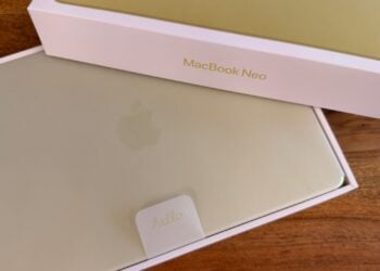 Halb geöffnete Verpackung des MacBook Neo in Citrus, das Gerät liegt noch in der Schutzhülle im Karton