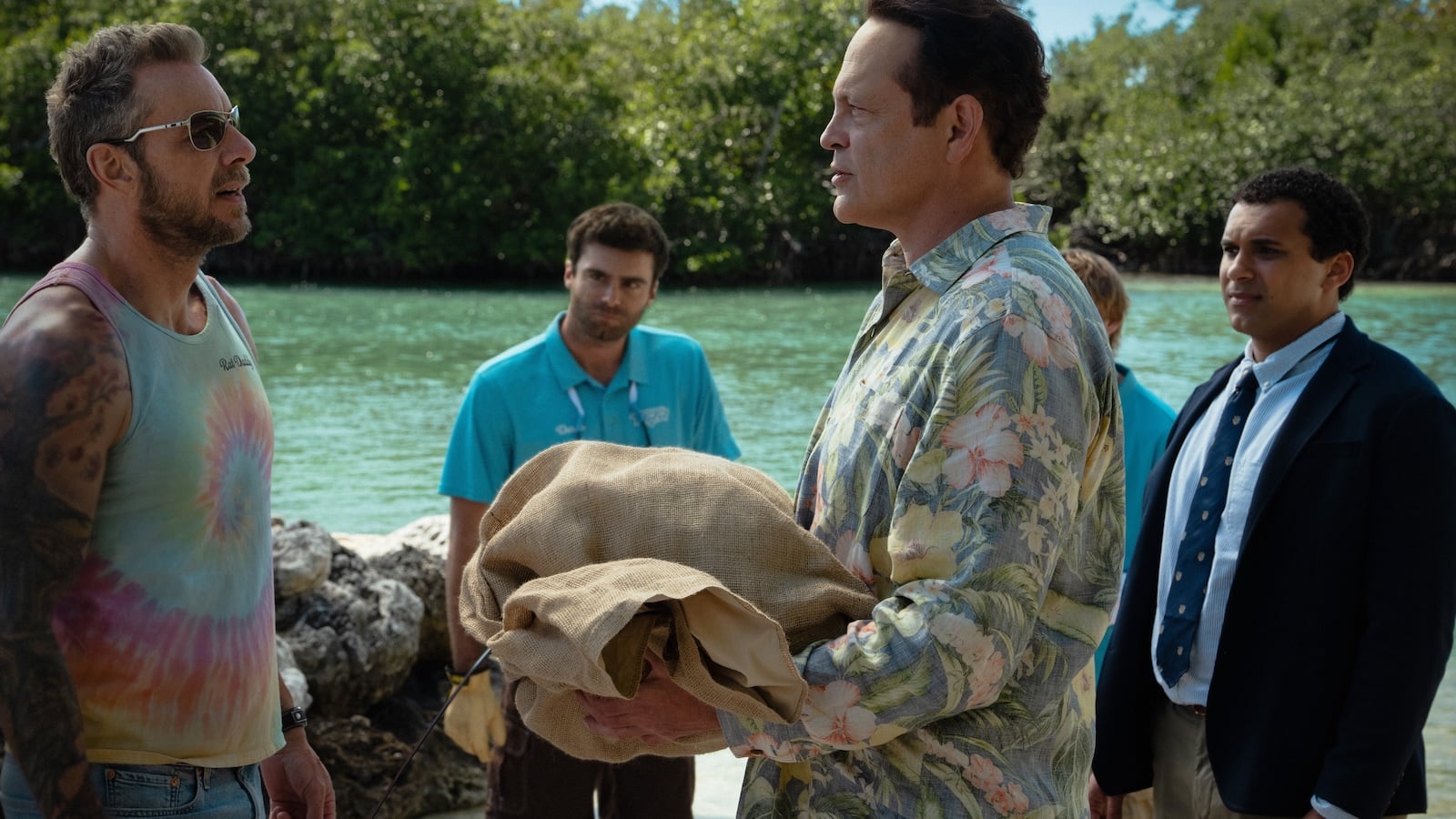 Scene from Bad Monkey season two with Vince Vaughn and Dax Shepard at a mangrove shoreline