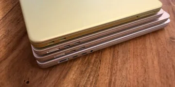 Vier gestapelte MacBooks von der Anschlussseite mit MagSafe 3 und USB-C, wobei je nach Modell ein anderes MacBook Netzteil die volle Ladegeschwindigkeit erreicht
