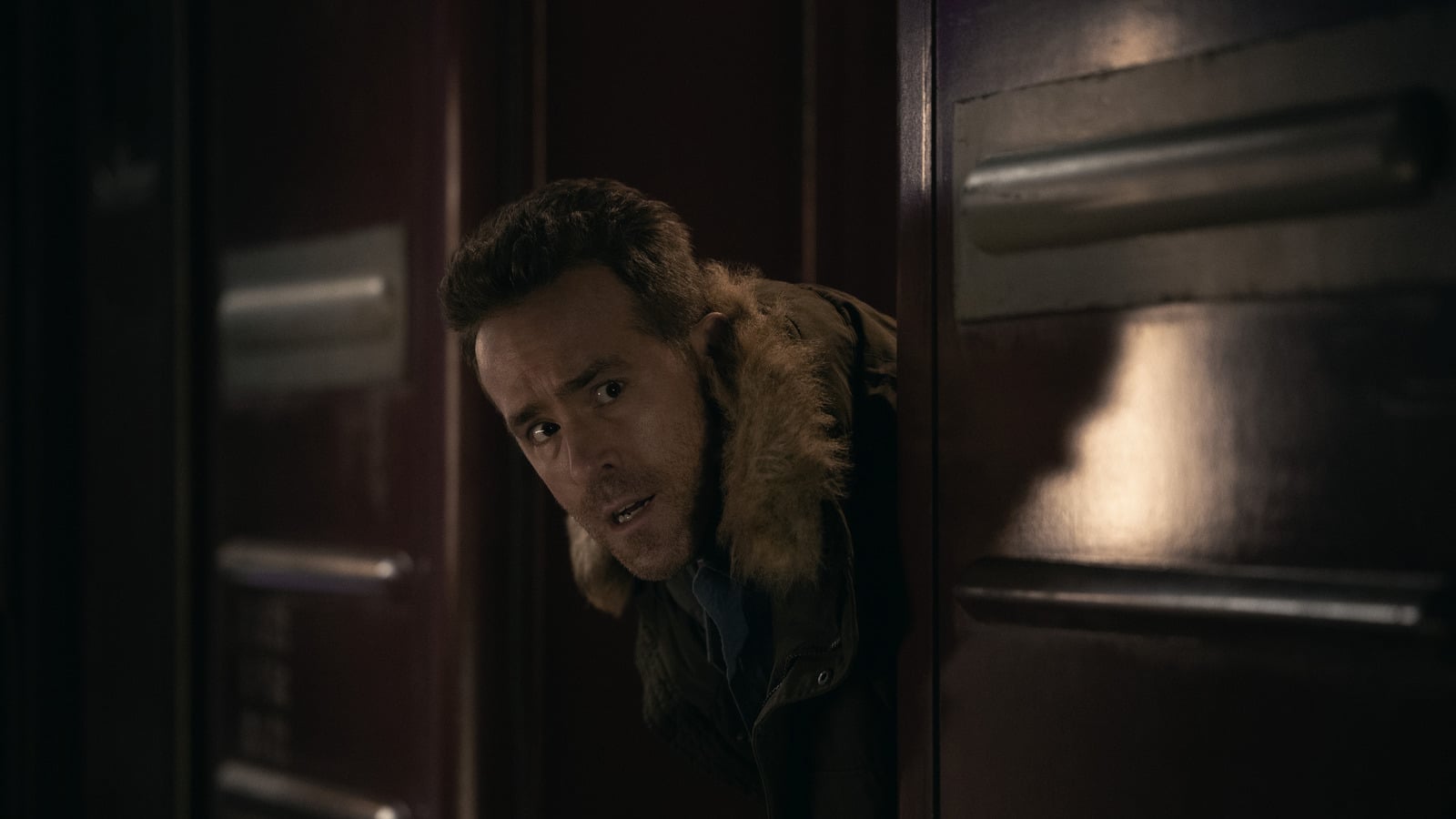 Ryan Reynolds späht um eine Zugtür, die Action-Komödie Mayday startet im Herbst 2026 bei Apple TV
