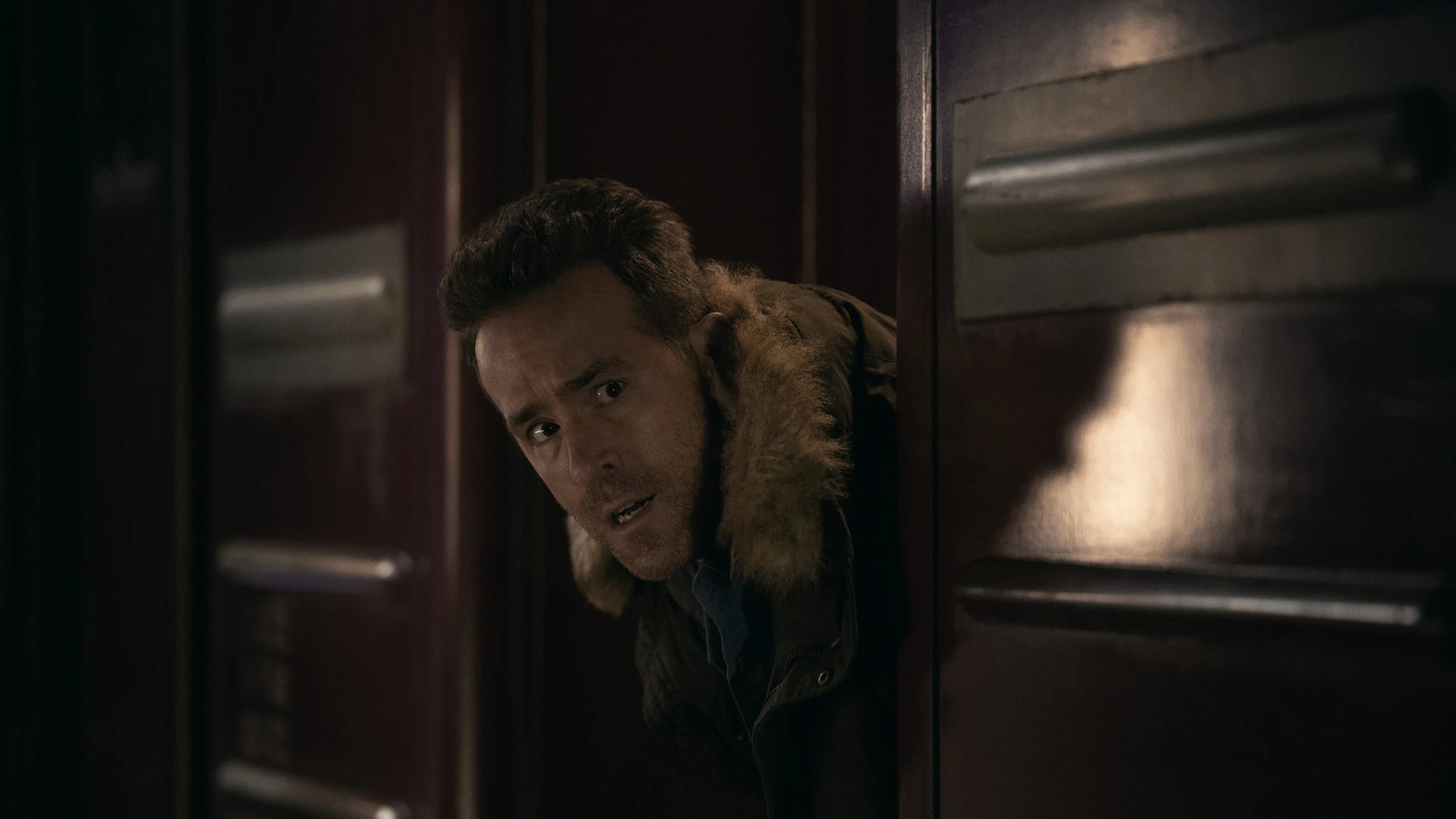 Ryan Reynolds späht um eine Zugtür, die Action-Komödie Mayday startet im Herbst 2026 bei Apple TV