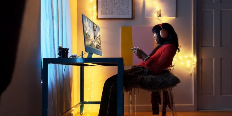 Blue 24-inch iMac on a desk in a dimly lit room, the display technology that could switch to five emitting layers in an OLED iMac