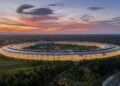 Symbolic image of Apple's leadership team: Apple Park from the air, illuminated at sunset.