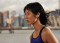 Läuferin mit AirPods im Regen, Ohrhörer sind die größte Gattung im Wearables-Markt