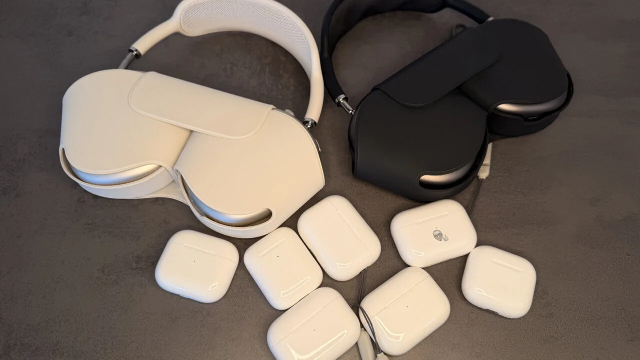 Mehrere AirPods Ladecases und zwei AirPods Max auf einem grauen Untergrund, Sinnbild für die AirPods Firmware aller Modelle