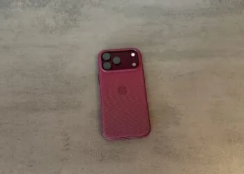 Rückseite eines iPhone 18 Pro Max in weinroter Hülle auf grauem Untergrund, betroffen von der verlängerten Apple Qualcomm Patentlizenz