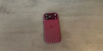 Rückseite eines iPhone 18 Pro Max in weinroter Hülle auf grauem Untergrund, betroffen von der verlängerten Apple Qualcomm Patentlizenz